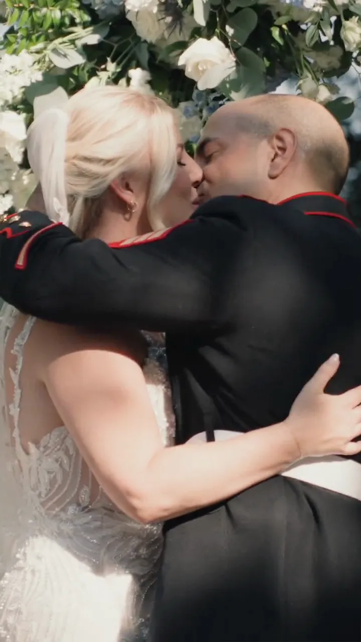Chris and Jenn embracing under a floral arch