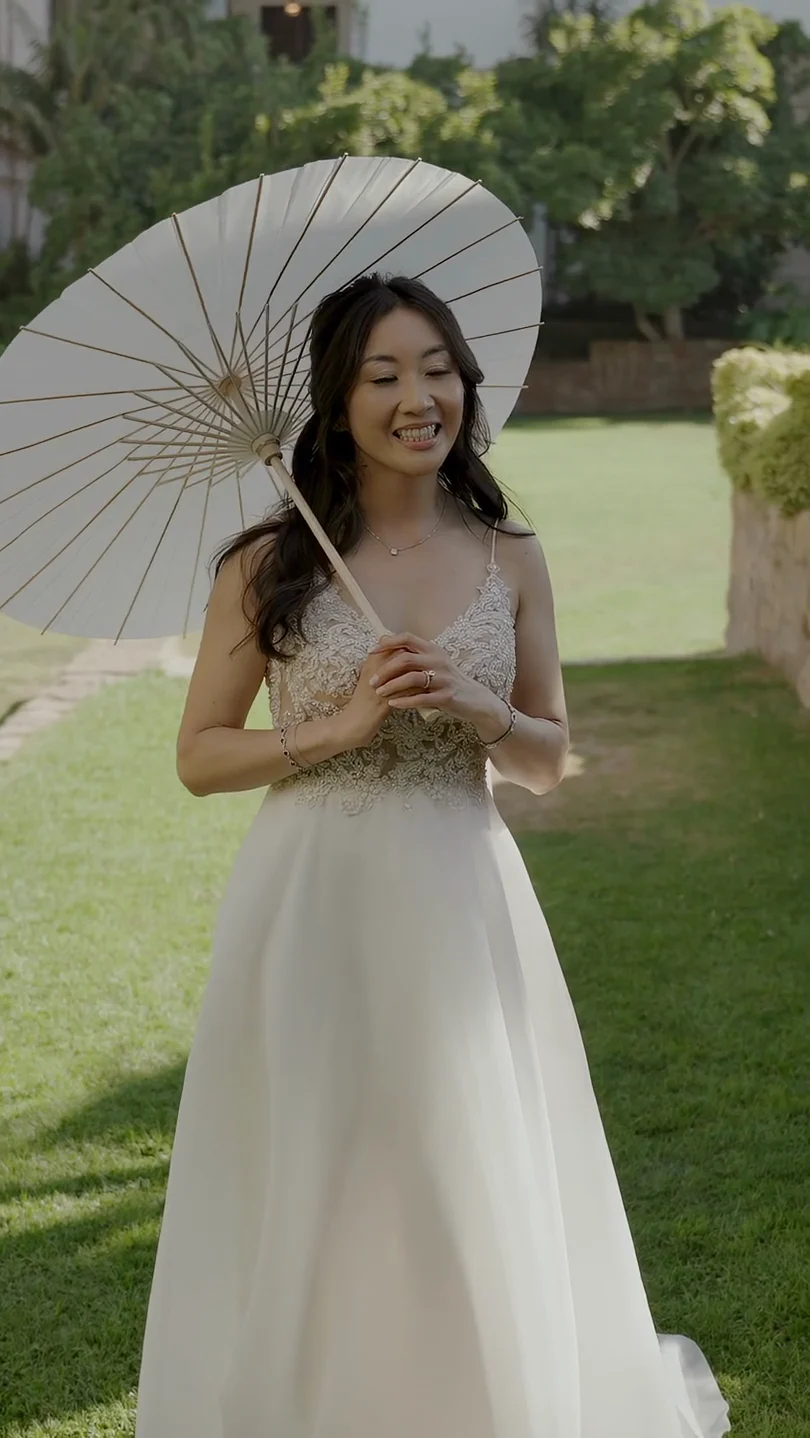 Natalie in her gown with a parasol on the lawn