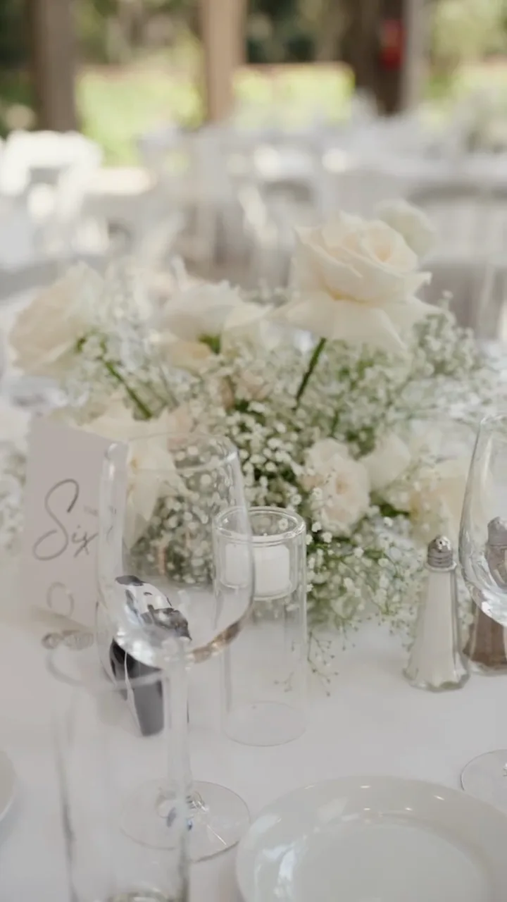 A set table with white florals and hills behind